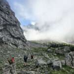 Eine Gruppe Wanderer läuft einen steilen Berghang hoch